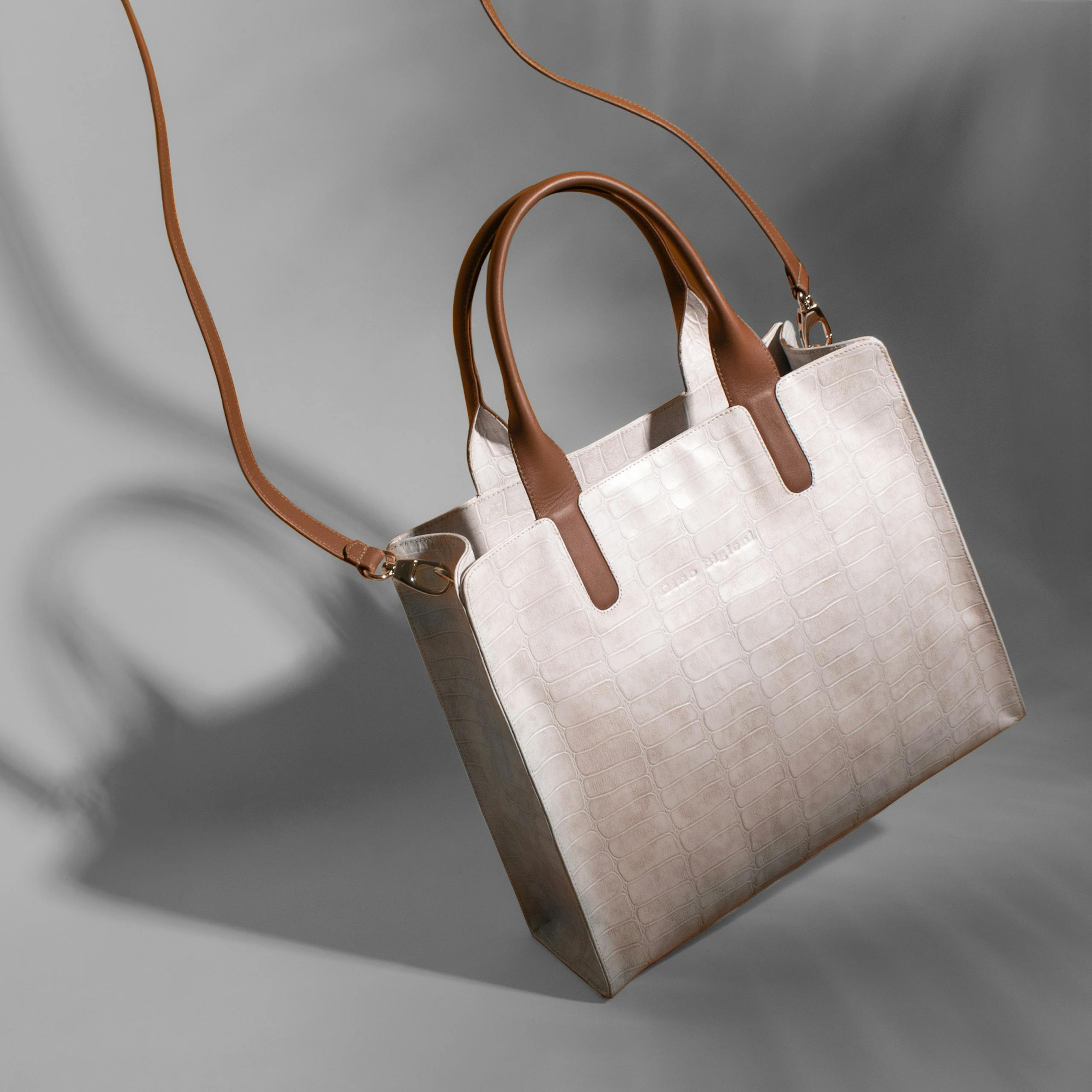 Luxury crocodile leather handbag in a studio shoot showcasing elegance and style.